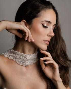 A graceful portrait of a woman wearing a pearl necklace and posing elegantly.